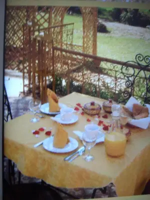 a table with plates of food and a candle on it at Kasbah Itrane in Tamnougalt