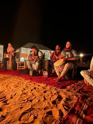 a group of people sitting in chairs on a stage at Camp Sakura Desert Dream in Merzouga