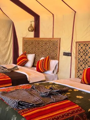 a bedroom with two beds in a tent at Riad Ksar Merzouga in Merzouga