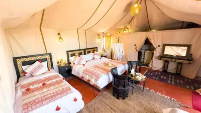 a bedroom with two beds in a tent at Merzouga Alicante Luxury Camp in Merzouga