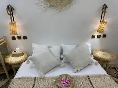 a bedroom with a white bed with pillows at Dar Mgouna Roses in Kalaat MGouna