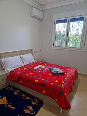a bedroom with a red comforter on a bed at Dar Latifa in Tinerhir