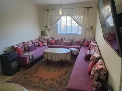 a living room with a purple couch and a table at La belle vue in Ifrane