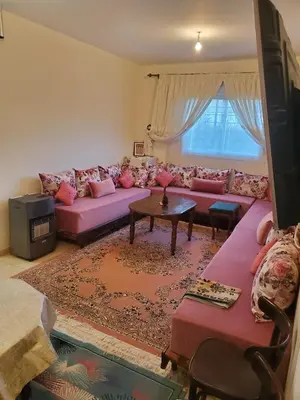 a living room with a purple couch and a table at La belle vue in Ifrane
