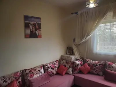 a living room with a pink couch and a window at La belle vue in Ifrane