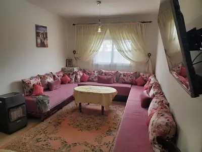 a living room with a purple couch and a table at La belle vue in Ifrane