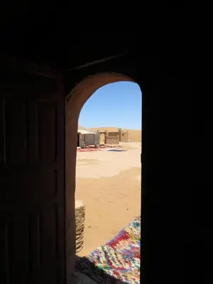an open door with a view of the desert at Chegaga Berber Camps in Mhamid