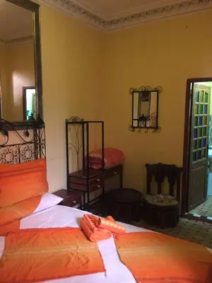 a bedroom with two beds and a mirror at Riad Selma in Meknès