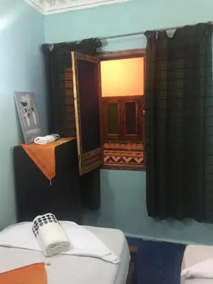 a room with two beds and a mirror at Riad Selma in Meknès
