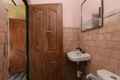 a bathroom with a wooden door and a sink at Gite Ogog Tacheddirt in Tacheddirt