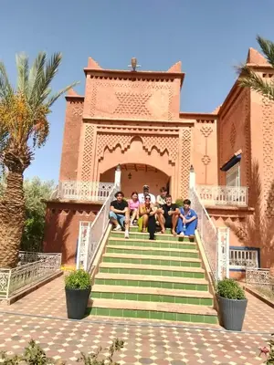 a group of people sitting on the steps of a building at chez l'habitant amazigh in Ouarzazate