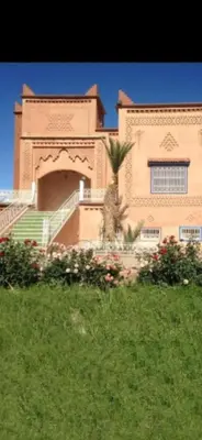 a building with a palm tree in front of it at chez l'habitant amazigh in Ouarzazate