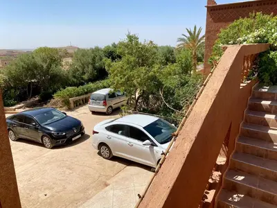 two cars parked in a parking lot next to a house at chez l'habitant amazigh in Ouarzazate