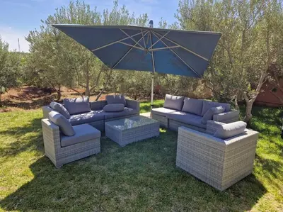 a patio with two couches and an umbrella at Villa Palmengarten Meknès bei Fes in Meknès