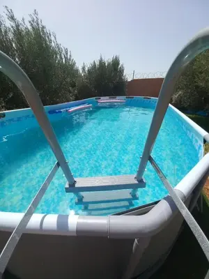 a swimming pool with a chair in front of it at Villa Palmengarten Meknès bei Fes in Meknès