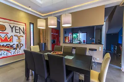 a dining room with a black table and chairs at Villa 751, Villa d'architecte, cuisinière, piscine chauffée et services in Marrakech