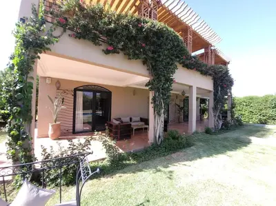 a house with a patio with a couch and flowers at Villa Tifira in Marrakech