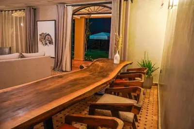 a long wooden table in a room with chairs at Villa Tifira in Marrakech
