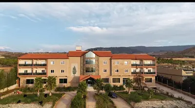 an aerial view of a building with palm trees at AUBERGE JOMANA PARK in Azrou