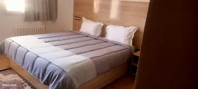 a large bed with white sheets and pillows in a bedroom at AUBERGE JOMANA PARK in Azrou