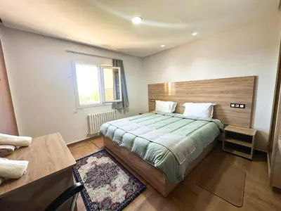 a bedroom with a large bed and a window at AUBERGE JOMANA PARK in Azrou