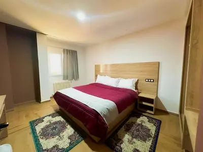 a bedroom with a large bed with a red blanket at AUBERGE JOMANA PARK in Azrou