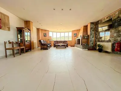 a large living room with wooden walls and a large floor at AUBERGE JOMANA PARK in Azrou