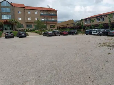 a parking lot with cars parked in front of a building at AUBERGE JOMANA PARK in Azrou
