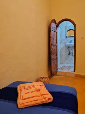 a bedroom with a bed and a sink and a mirror at Kasbah Ziwana - Guesthouse in Zagora