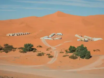 an aerial view of a desert with trees and buildings at Aisha Luxury Camp in Merzouga
