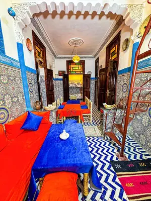 a room with a blue and red bed and a table at Hostel Speakeasy Fes in Fès