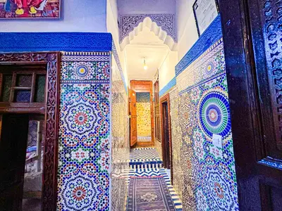 a hallway with blue and white tiles on the walls at Hostel Speakeasy Fes in Fès