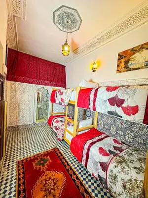 a bedroom with two beds with red and white covers at Hostel Speakeasy Fes in Fès