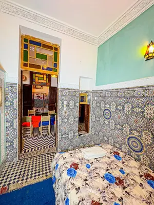 a bedroom with a bed and a tiled wall at Hostel Speakeasy Fes in Fès