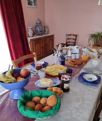 a table with a bowl of fruit on top of it at Domaine des Sloughis in Meknès