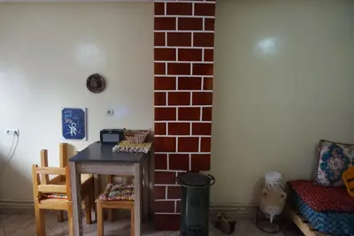 a room with a table and chairs and a brick wall at SamIfrane1 in Zaouia dʼIfrane
