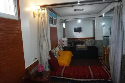 a living room with a couch and a television at SamIfrane1 in Zaouia dʼIfrane