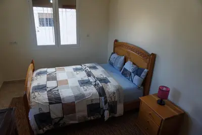 a bedroom with a bed with a quilt and a window at SamIfrane1 in Zaouia dʼIfrane