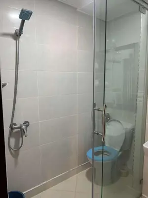 a bathroom with a glass shower with a toilet at Marwan's apartment Ifrane Gardens in Ifrane
