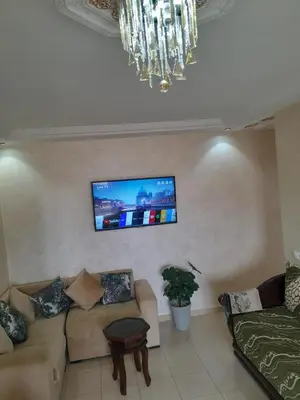 a living room with a couch and a flat screen tv at Marwan's apartment Ifrane Gardens in Ifrane