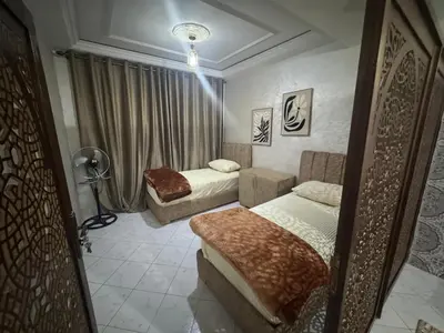 a bedroom with two beds and a lamp in it at Tranquility In the Center of Fez in Fès
