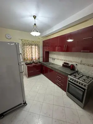 a kitchen with red cabinets and a stove top oven at Tranquility In the Center of Fez in Fès
