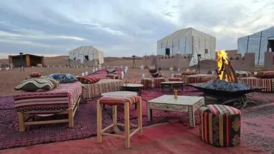 a group of chairs and tables in the desert at Nejma luxury camp erg chegaga in El Gouera
