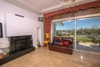 a living room with a leather couch and a fireplace at Villa Meriem, Fès in Oulad Tayeb