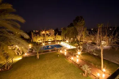 a backyard at night with a swimming pool and lights at Villa Meriem, Fès in Oulad Tayeb