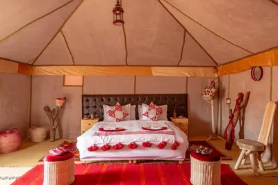 a bedroom with a bed in a tent at Alibaba Merzouga Camp in Merzouga