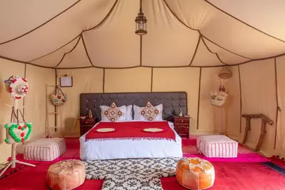 a bedroom with a bed in a tent at Alibaba Merzouga Camp in Merzouga