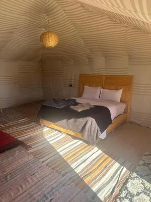 a bedroom with a large bed in a room at Morocco Desert Luxury Camp in Merzouga