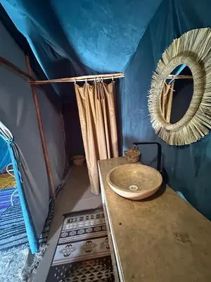a bathroom with a sink and a mirror in a tent at Morocco Desert Luxury Camp in Merzouga