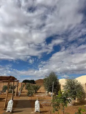 a view of a desert under a cloudy sky at Morocco Desert Luxury Camp in Merzouga